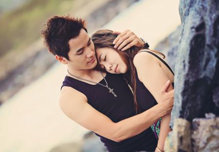 Man Hugging a Woman Wearing Black Tank Top