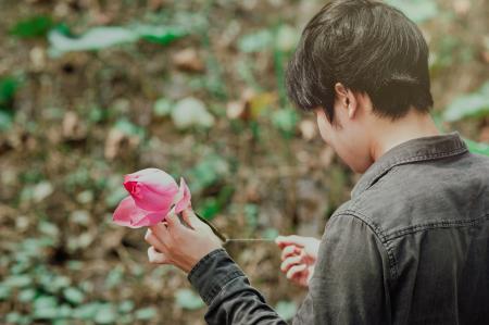 Man in Black Denim Jean Holding Pink Flower