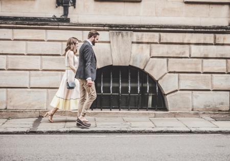 Man in Black Formal Suit Jacket Walking Together With Woman in White Sleeveless Dress