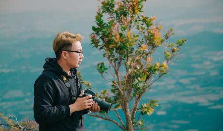Man in Black Jacket in Front Green Plant