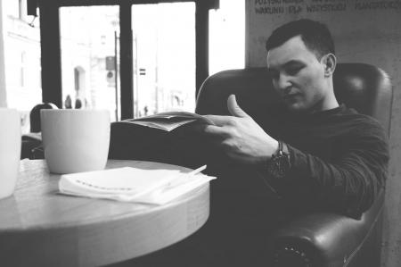 Man in Black Sweater Reading Newspaper