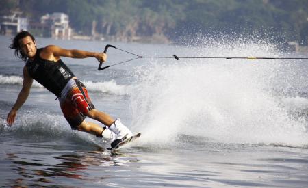 Man in Black Tank Top and Red Shorts Waveboarding