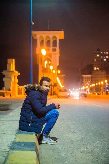 Man in Black Zip-up Hoodie Near White Building