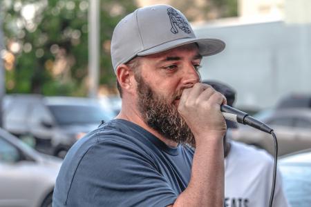 Man In Crew-neck Shirt And Grey Cap Holding Black Corded Microphone