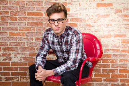 Man In Dress Shirt Sitting On Red Armchair