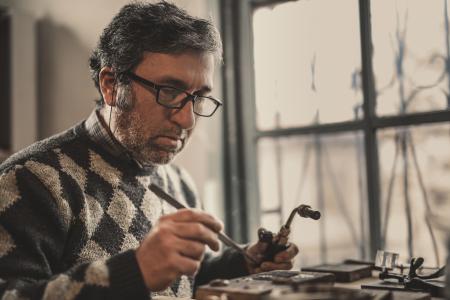 Man in Gray and Black Argyle Sweater Holding Acetylene Torch