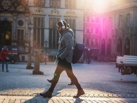 Man in Gray Hooded Jacket Walking on Gray Bricks Pavement
