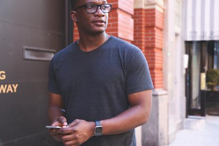 Man in Gray T-shirt Near Black Metal Wall