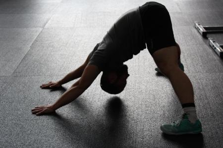 Man in Grey Shirt Doing Yoga on Gray Ceramic Tile Floor