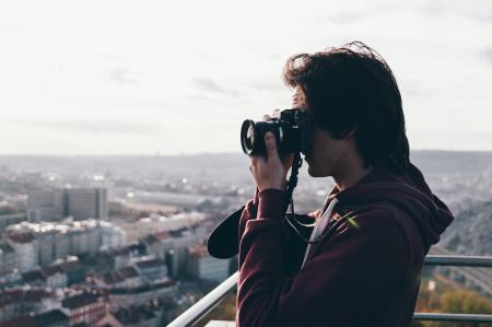 Man in Maroon Jacket Using Camera