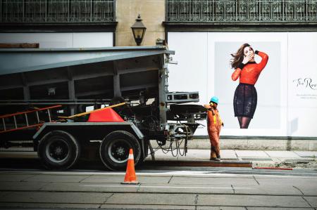 Man in Orange Safety Suit Standing Beside Truck Bed