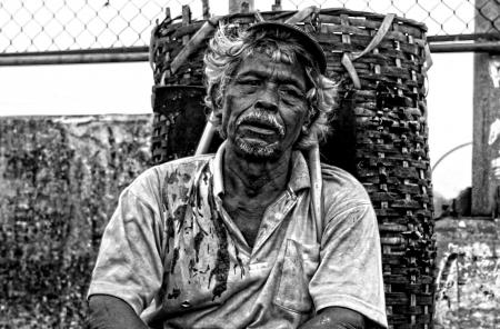 Man in Polo Shirt Sitting Near Brown Woven Basket Black and White Photography