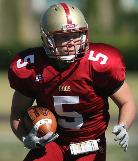 Man in Red and White Roos 5 Football Jersey Playing Football