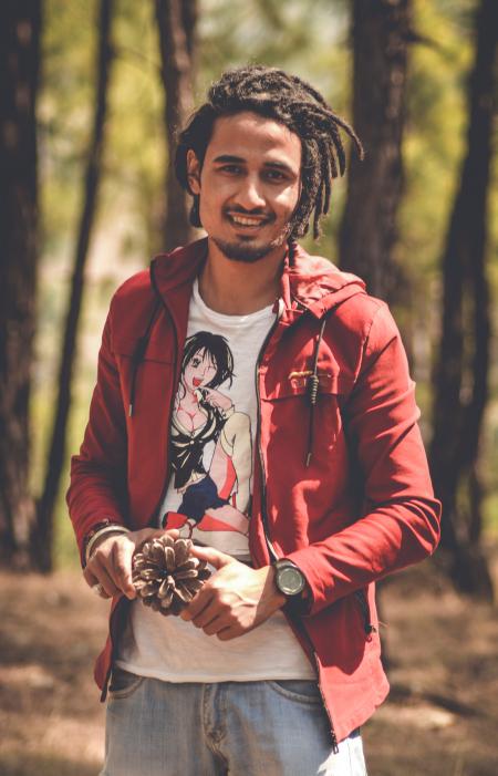 Man in Red Zip-up Hoodie Holding Pine Cone