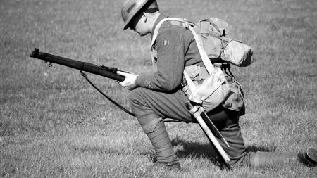 Man in Soldier Suit Holding Gun Knees Down in the Ground