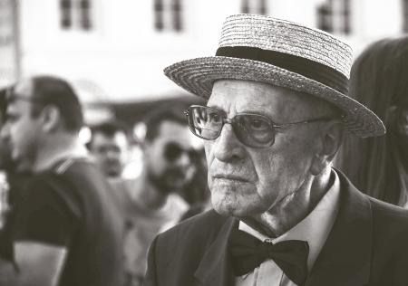 Man in Straw Hat Wearing Bow Tie With People