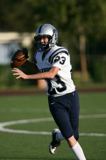 Man in White and Black Football Jersey Playing on Field during Daytime