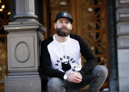 Man in White and Black Pullover Shirt Leaning on Black Post