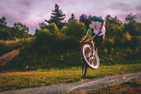 Man in White and Green Raglan Elbow-sleeved Shirt Biking at Daytime