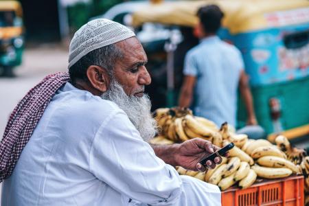 Man in White Thobe Coat Holding Mobile Phone