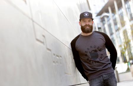 Man Leaning Against the White Concrete Wall