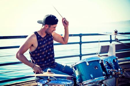 Man Playing Drum Near Bay at Day Time