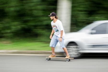 Man Playing Longboard on Road