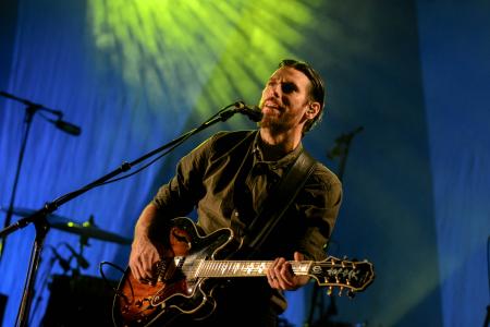 Man Playing Red and Black Electric Guitar on Stage