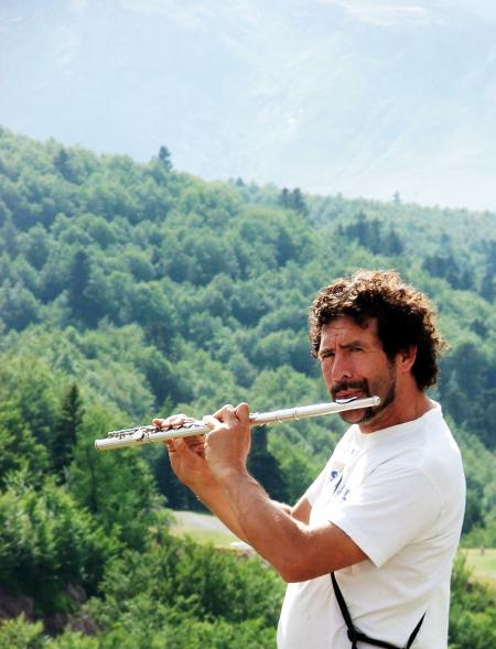 Man playing the flute in the mountains