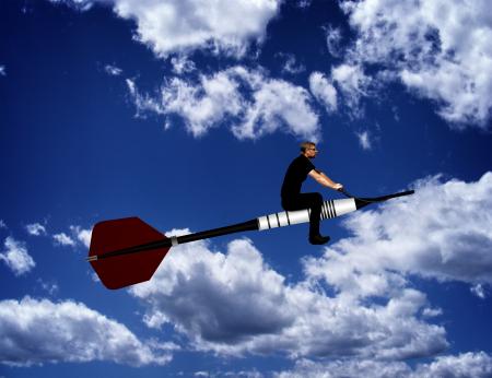 Man riding a dart through the sky