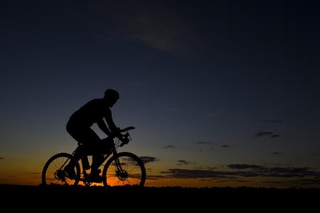 Man Riding Bicycle during Nightfall