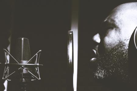 Man Singing Near Pop Filter and Condensing Microphone