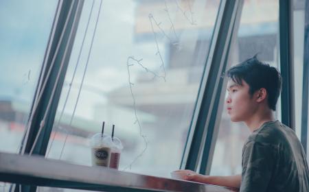 Man Sitting Beside Table Near Plastic Cups