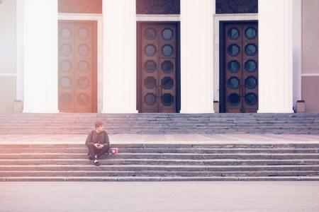 Man Sitting on a Concrete Stair Waiting for Someone during Daytime