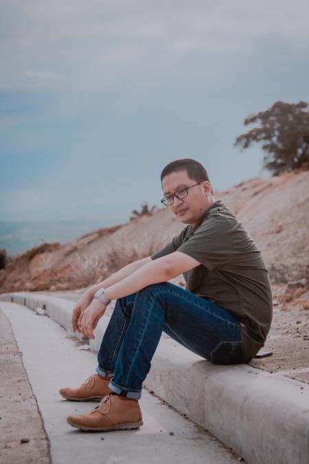 Man Sitting On Road Gutter