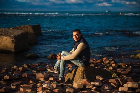 Man Sitting on Stone Under the Blue Sky