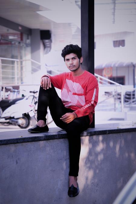 Man Sitting on Wall Near Motorcycle