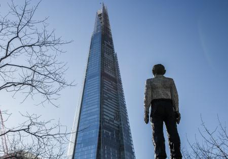 Man Standing in Front of a Sunrise Building Under Blue Sky