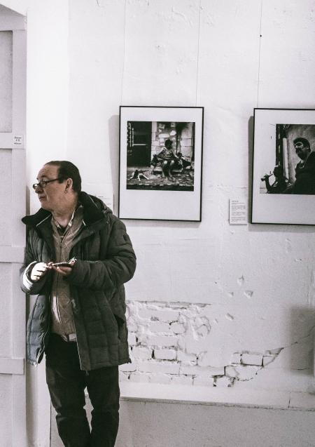 Man Standing in Front of Grayscale Gallery Photo