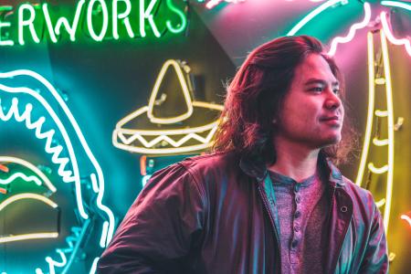 Man Standing in Front of Neon Signages