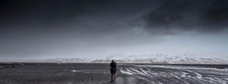 Man Standing on Gray Dessert Under Gray Cloudy Sky during Daytime