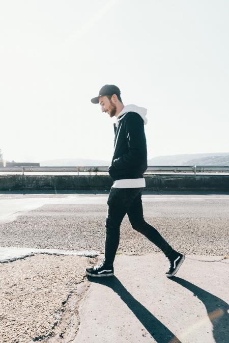 Man Walking on Road Under the Sun