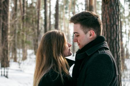 Man Wearing Black Coat Facing Woman Wearing Black Coat Near Tree