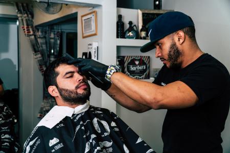 Man Wearing Black Shirt Trimming the Hair of Man