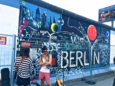 Man Wearing Black Waistcoat and White Tank Tops Standing Near a Mural