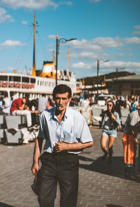 Man Wearing Blue Button-up T-shirt and Black Dress Pants Smoking Cigarette