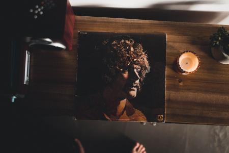 Man Wearing Brown Collared Shirt Photo on Brown Wooden Cabinet