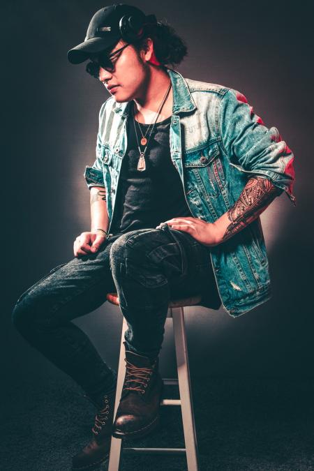 Man Wearing Denim Jacket While Sitting on Chair