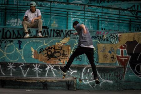 Man Wearing Geay Shirt Playing Skateboard