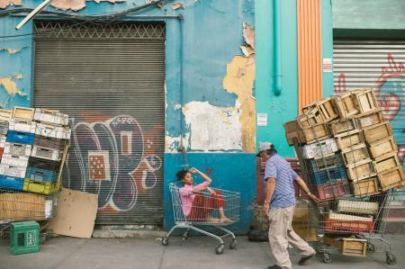 Man Wearing Gray Cap and Blue Shirt Holding Shopping Cart